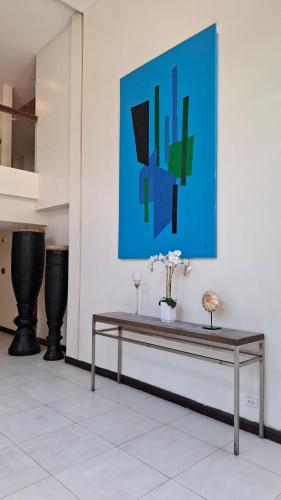 a table in a room with a painting on the wall at Maison Brise Condominium Unit Pico De Loro Nasugbu in Nasugbu