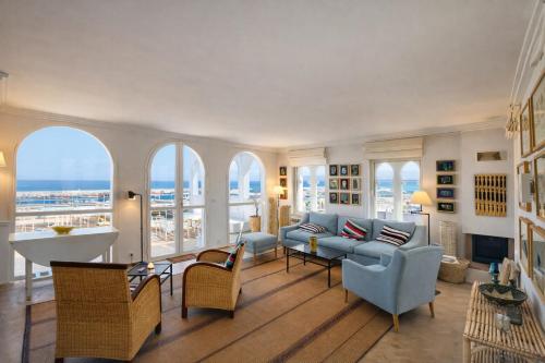 a living room with a couch and chairs and windows at Le balcon de tanger in Tangier