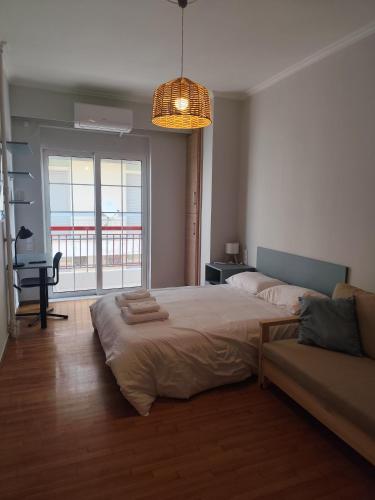 a bedroom with a large bed and a couch at Parastaseis One Bedrooom Flat Georges Square in Patra