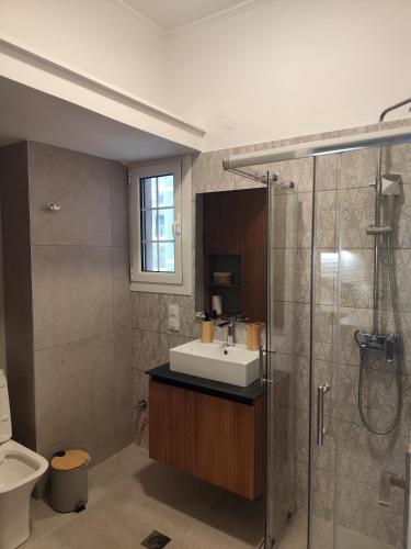 a bathroom with a sink and a shower at Parastaseis One Bedrooom Flat Georges Square in Patra