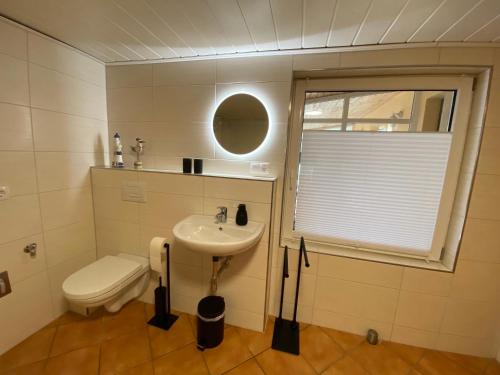 ein Badezimmer mit Waschbecken, Toilette und Fenster in der Unterkunft Beetzseeperle in Brandenburg an der Havel