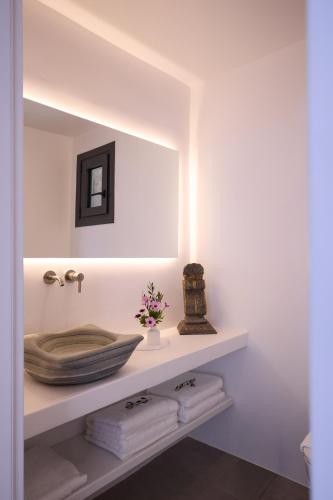 a bathroom with a shelf with a mirror and towels at Villa Apollo in Kionia