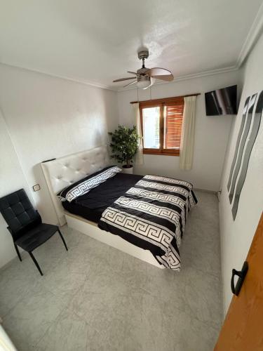 a bedroom with a bed and a chair and a window at Club aldeas de taray in San Javier