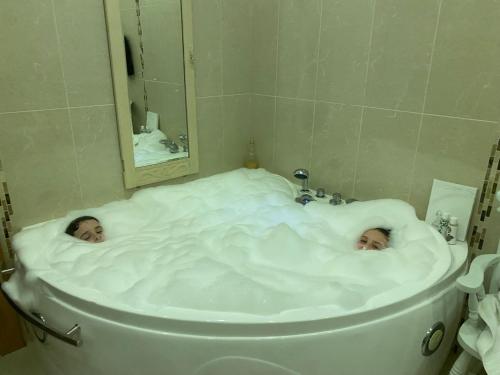 a baby laying in a bath tub in a bathroom at Hunthill in Tulach an Iarainn