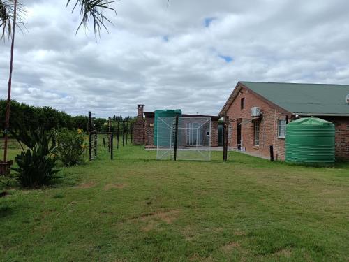 a yard with a house and a fence and a building at IVCA Cottage in Addo