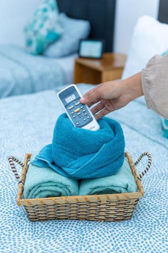 a person holding a remote control on a pile of towels at The Beach Break Hotel El Zonte in El Zonte