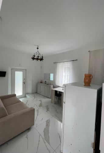 a white living room with a couch and a table at Apartment with garden PERLA NERONIANA in Anzio