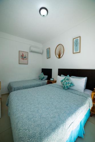 a bedroom with two beds with blue comforters at The Beach Break Hotel El Zonte in El Zonte