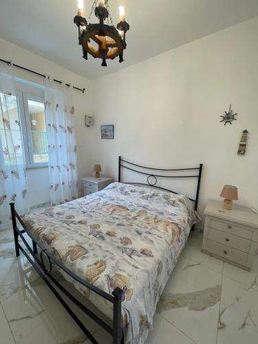 a bedroom with a bed and a chandelier at Apartment with garden PERLA NERONIANA in Anzio