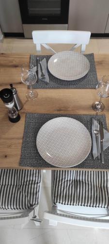 a table with two white plates on top of it at Parastaseis City Flat Central in Patra