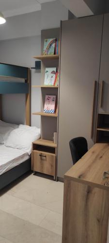 a bedroom with a bed and a desk with a chair at Parastaseis City Flat Central in Patra