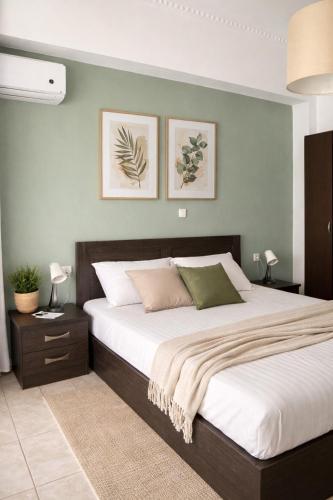 a bedroom with a large bed with green walls at Midway Point Apts in Heraklio