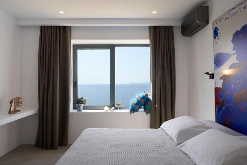 a bedroom with a bed and a large window at Villa Apollo in Kionia