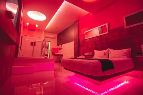 a red room with a bed and a bathroom at COSMOPOLITAN Autohotel in Boca del Río