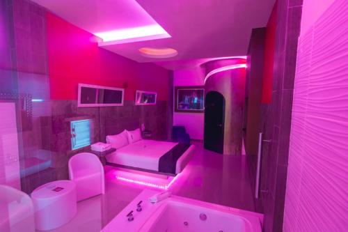 a pink bathroom with a tub and a sink at COSMOPOLITAN Autohotel in Boca del Río