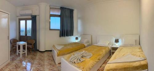 a hotel room with two beds and a window at mountain Luxor in Al Aqālitah