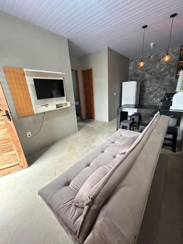 a large couch in a living room with a television at Chalé 1 - próximo à igreja do céu in Viçosa do Ceará