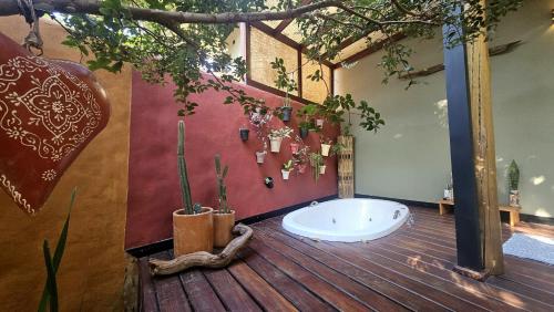 a bathroom with a bath tub on a wooden floor at Casas Vila Encantada Refúgio, conforto e natureza, apenas 2 min da avenida in Alto Paraíso de Goiás