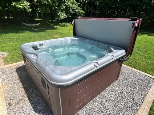 a large hot tub sitting in the grass at Ski Chalet w-Hot Tub, Only 3 min to Sunday River ski lifts! in Bethel