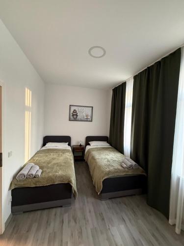 two beds in a bedroom with curtains and wooden floors at Andoniev in Salzelmen