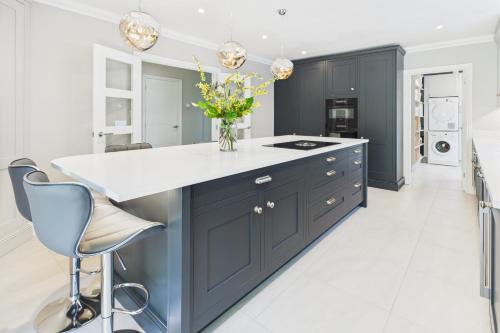 a kitchen with navy blue cabinets and white countertops at King size room with own bathroom & livingroom in a luxury home, free WiFi, HOMESTAY in West Byfleet