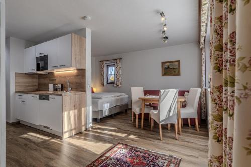 a kitchen and a living room with a table in a room at Haus Hammerer in Ellmau