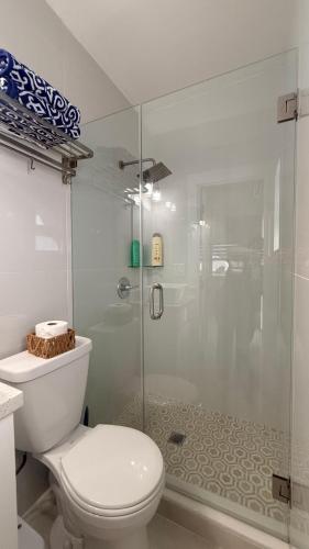 a bathroom with a toilet and a glass shower at Comfortable modern apartment- central location. in Miami