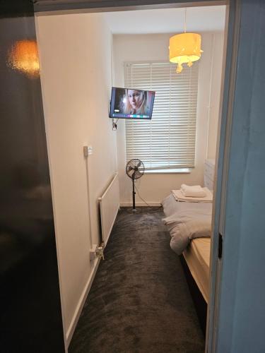 a room with a bed and a flat screen tv at M4 Victoria Hub in Newport
