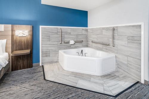 a bathroom with a white tub in a room at Holiday Inn Express Hotel & Suites Loveland by IHG in Loveland