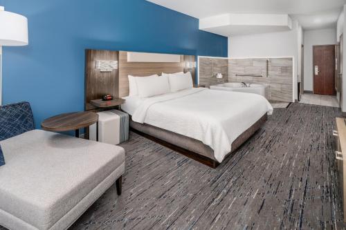 a hotel room with a large bed and a bathroom at Holiday Inn Express Hotel & Suites Loveland by IHG in Loveland