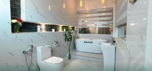 a bathroom with a toilet and a sink and a tub at شاليه روجا Roja Chalet in As Sulayf