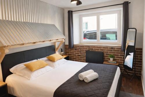 a bedroom with a large bed with two towels on it at Artist Retro Disneyland Paris P3 in Coutevroult