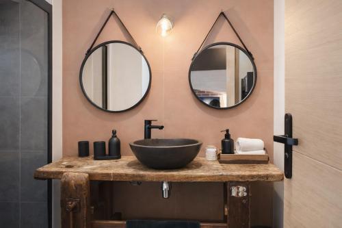 a bathroom with a sink and two mirrors on the wall at Artist Retro Disneyland Paris P3 in Coutevroult