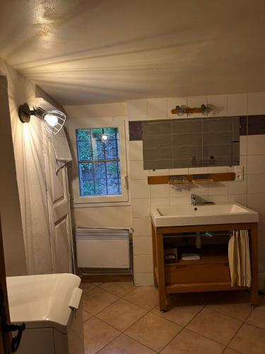 a small bathroom with a sink and a window at Gite Thérèse in Montferrer