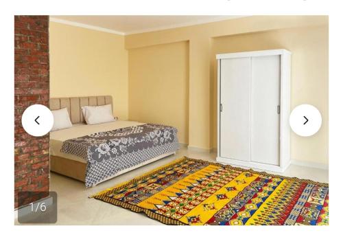 a bedroom with a bed and a rug next to a door at Karima house B in Al Aqālitah