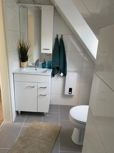 a white bathroom with a sink and a toilet at R&A Unterkunft in Oberhausen