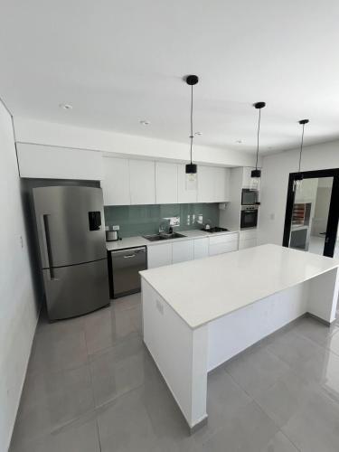 a kitchen with a white counter and a refrigerator at Casa Granadero Baigorria in Paganini
