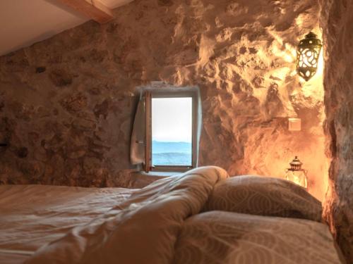 a bedroom with a window in a stone wall at Le Logis - Maison authentique avec jardin et vue panoramique in Mons