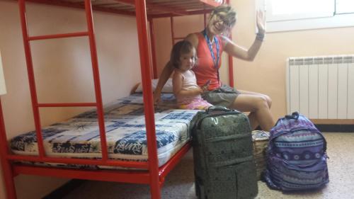 a woman and a child sitting on a bunk bed at Alberg Costa Brava in Llança