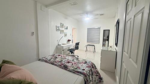 a bedroom with a bed and a desk and a table at Comfortable modern apartment- central location. in Miami