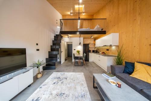 a large living room with a couch and a kitchen at Muhu Apartments in Velké Hamry