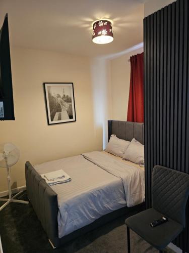 a small bedroom with a bed and a chair at M4 Victoria Hub in Newport