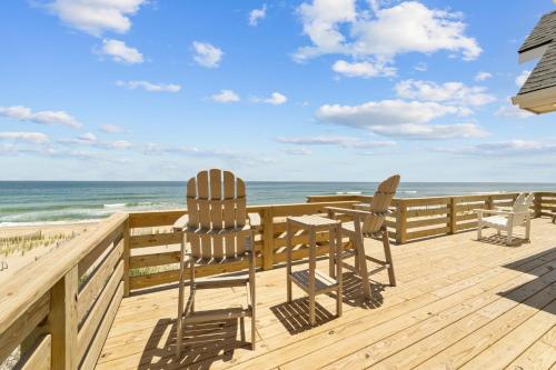 two chairs and a table on a deck overlooking the beach at 7675 - Sweet Caroline in Avon