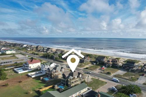 an aerial view of a beach with a house with a white arrow at 5468 - Mermaids' Lagoon in Nags Head