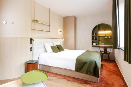 a bedroom with a white bed and a green chair at AUBERGE FRANKENBOURG in La Vancelle