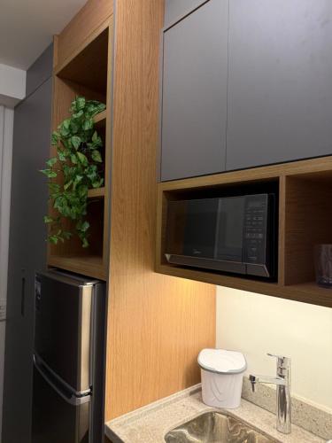a kitchen with a black refrigerator and a microwave at Maison Perdizes 506 - Até 6 pessoas - Allianz Parque in São Paulo