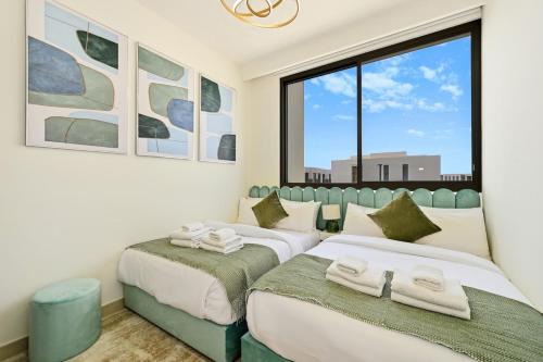 two beds in a room with a window at Warm and Cozy 4BR Villa with Pool Access in Dubai