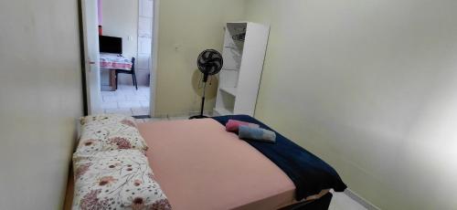 a small room with a bed and a fan at pousada Adriane in Rio do Sul