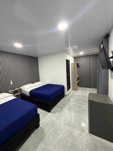 a hotel room with two beds and a sink at Bless Hotel in San Andrés