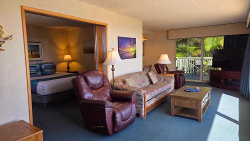 a hotel room with a couch chair and a bed at Cabrillo Inn at the Beach in Santa Barbara